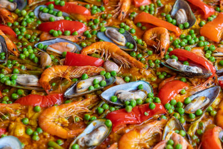Spanish seafood paella in fry pan with mussels, shrimps and vegetables. Seafood paella background, close up, traditional spanish rice dishの写真素材