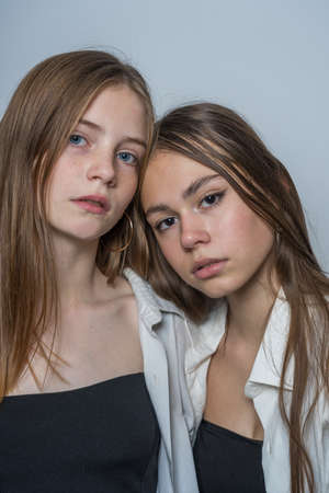 Portrait of two charming young girls, indoors, close up
