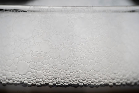 Part of a glass of cold drink with white froth, close up