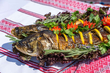 Delicious stuffed carp with lemon, tomato and herbs, close up, Ukraaineの写真素材