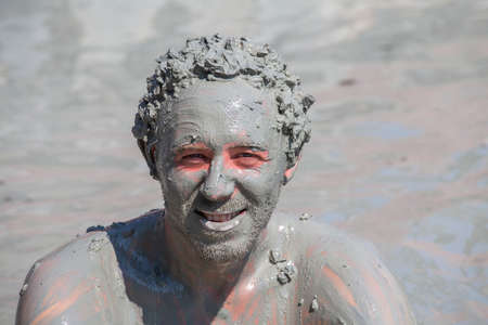 Mud treatment at the Dalyan, Turkey. Portrait happy man who takes a mud bath, close upの写真素材