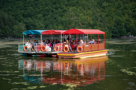 Medjuvrsje lake, Serbia - September 05, 2021: European tourists sail on a tourist boat along the...