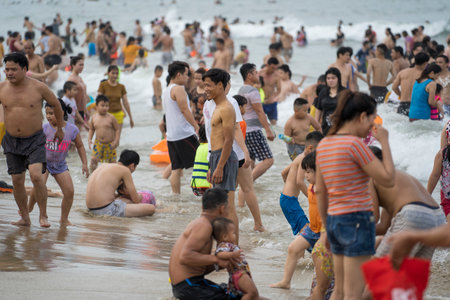 Danang, Vietnam - june 14, 2020 : Vietnamese families relax on the beach and swim in the sea in the evening after work on the city Danang, Vietnam. Relax on the beachのeditorial素材
