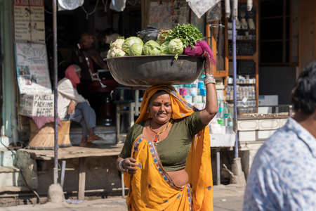 Pushkar, India - Nov 17, 2018 : Indian woman selling vegetables in the street food market in holy city Pushkar, Rajasthan, Indiaのeditorial素材