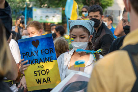 Bangkok, Thailand - Feb, 27, 2022 : Demonstrators, holding banners and Ukrainian flags, protested Russias intervention in Ukraine in front of the Russian embassy in Bangkok, Thailandのeditorial素材
