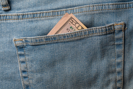 Fifty dollar bill in the pocket of the jeans, close up