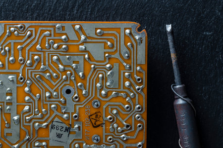 Old printed circuit board background. Vintage circuit board with soldering trace, close up, top view. Backside brown electronic chip retro style designの写真素材