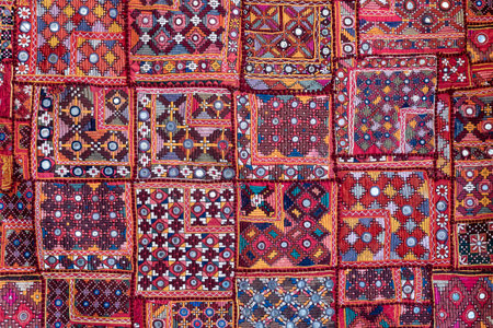 Detail old colorful patchwork carpet in background, India. close upの写真素材