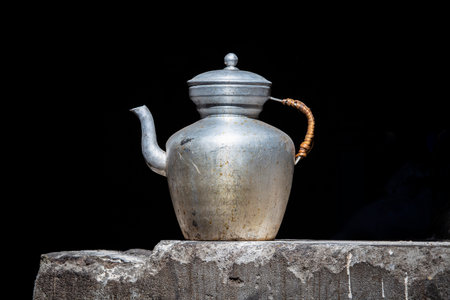 Old handmade Tibetan kettle on black background, close up. India, Ladakhの写真素材