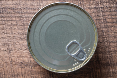 Closed canned food on a wooden background, close up, top viewの写真素材