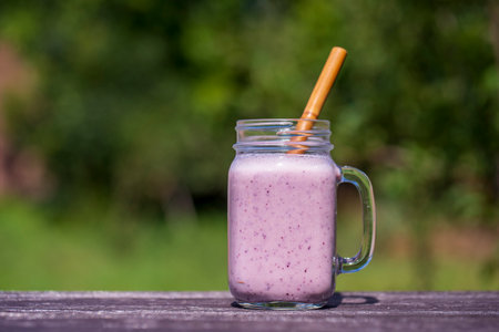Delicious milky blueberry smoothie in a glass mug on the table, close upの写真素材