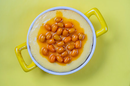 Sea buckthorn cheesecake on yellow background, top view, close upの写真素材
