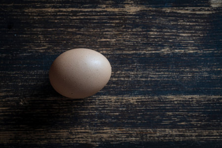 Chicken egg on a wooden table, close up, top view, copy space