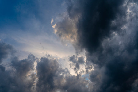 In the evening, dark gray clouds fly across the sky. Puffy fluffy gray clouds at spring day during...