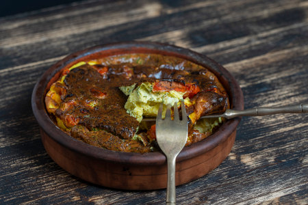 Ceramic bowl with vegetable frittata, simple vegetarian food. Frittata with egg, tomato, pepper,...