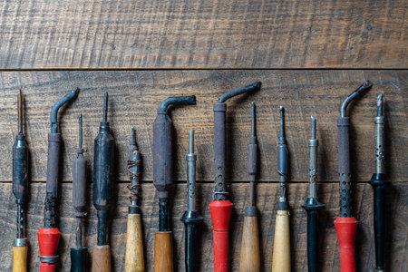 A lot of antique vintage soldering irons on the wooden background, close up, top view, copy spaceの写真素材