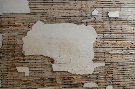 Old dry plaster ceiling on a wooden lattice, close up. Ceiling of an abandoned apartment. Renovating...
