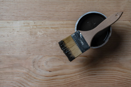 Top view on paint brush on the opened can on the wooden table background or floor painting and renovation repairing concept, copy spaceの写真素材