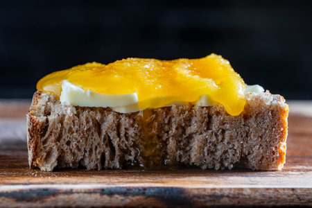 Sandwich made from a slice of sourdough bread with butter and honey prepared for breakfast, close up