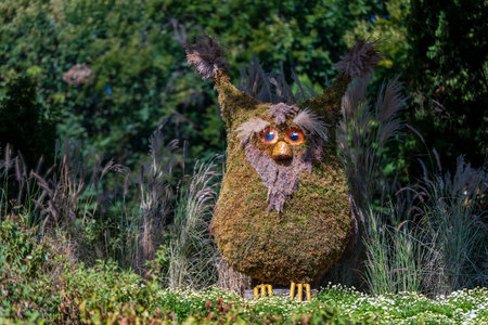 Decorative owl with plants and flowers in the garden, close upの写真素材