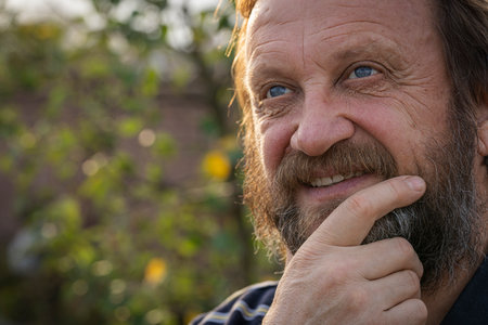 Portrait of a thinking or dreaming or solve problems senior man. Elderly bearded caucasian male in nature. Face bearded caucasian male daydream of decision, planning solution and insight of questionsの写真素材