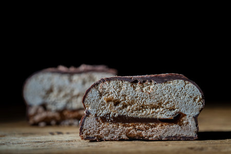 Glazed dessert consisting of delicate airy souffle with cream flavor, soft caramel with the addition of natural cocoa and sugar cookies on a wooden table, close upの写真素材