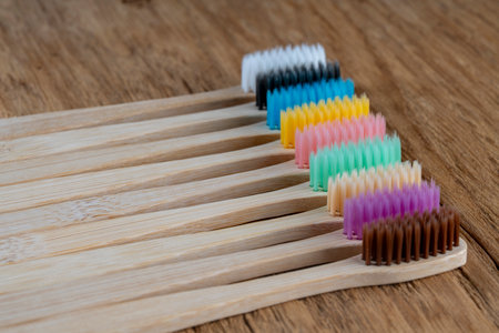 Set of multicolored bamboo toothbrushes on wooden background, close up. Zero waste, plastic free,...