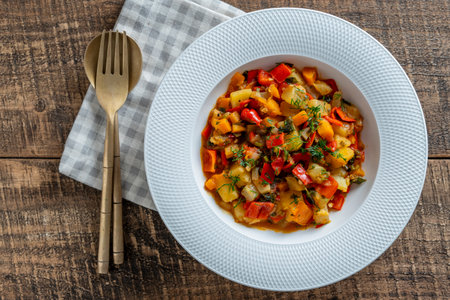 Vegetable stew in white plate on wooden background, close up. Healthy food. Vegan dish.Top viewの写真素材