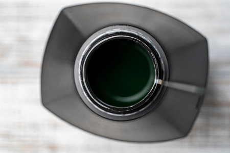 Motor oil container in white wooden background, close up, top view. Open motor oil in plastic jarの写真素材