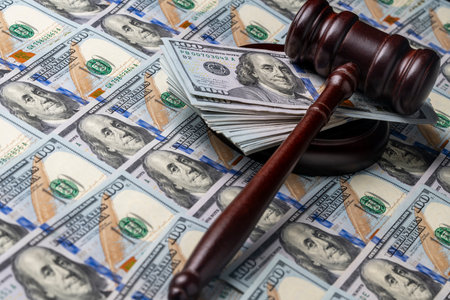 Wooden judge gavel, soundboard with US 100 dollar bills on the background, close up. Finance and...