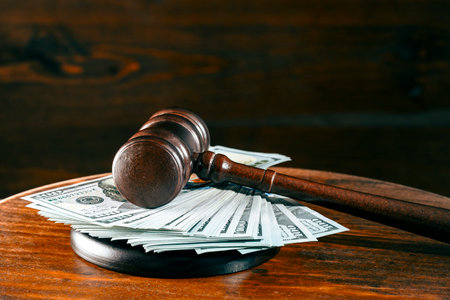 Wooden judge gavel, soundboard with dollars on a wooden table, close upの写真素材