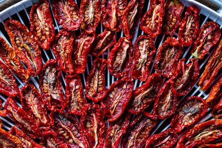 Dry red tomato on a drying tray for dehydrator, close up. A way to preserve vitamins. Vegetarian meal, healthy and usefulの写真素材