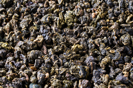 Pile of green dry leaves of tea oolong with milk aroma, close up. Background of dried green tea leaves, macroの写真素材
