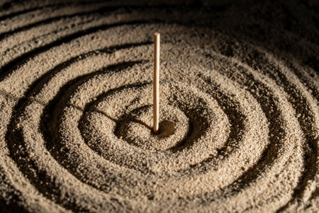 Stick, sunbeam and circles in the sand, close up. Sundial concept of meditation and tranquilityの写真素材