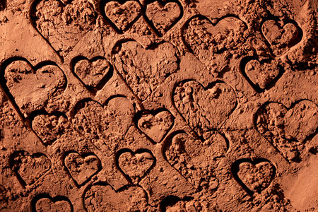 Natural dark brown cocoa powder with hearts, textured background, close up, top viewの写真素材
