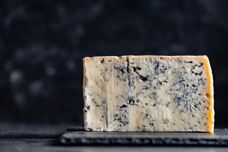 Piece of blue cheese on dark background, close upの写真素材