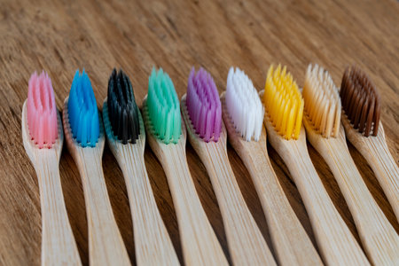 Set of multicolored bamboo toothbrushes on wooden background, close up. Zero waste, plastic free, eco friendly organic product conceptの写真素材