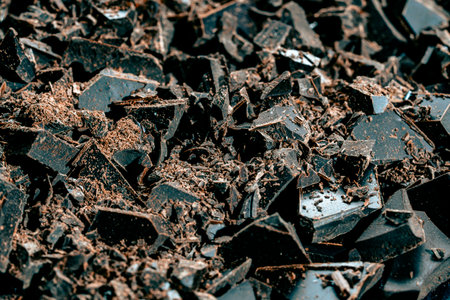 Pile broken dark chocolate bar on background, close up. Sweet food