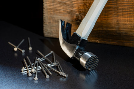 Multifunction shockproof steel hammer and nails, close up. Hand tool for working. Magnetic claw hammer for woodworking, nail suction hammerの写真素材