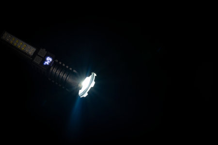High strong power led flashlight on a black background, close up. Tactical emergency spotlight with telescopic zoom, built-in battery, usb rechargeable, camping torchの写真素材