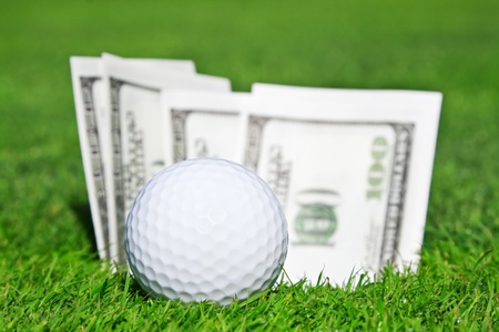 The golf ball sticking out of the money and the wellsの写真素材