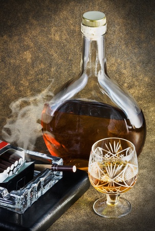 bottle of brandy and smoking a cigaretteの写真素材
