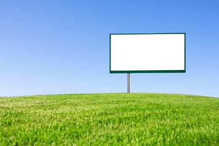 Blank billboard on green field and the blue sky in backgroundの写真素材