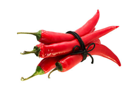 related acute red peppers isolated on a white cordの写真素材