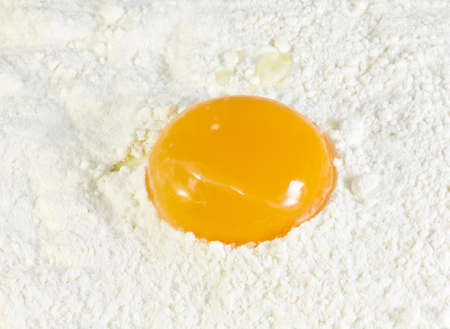 yellow egg yolk on wheat flourの写真素材