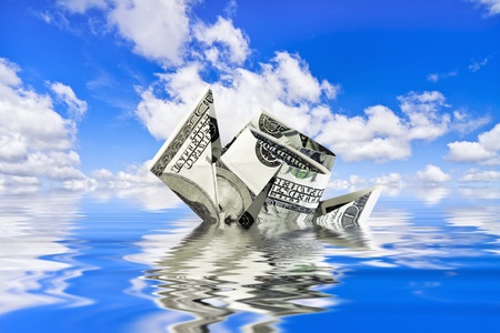 sinking ship of the dollar against the blue skyの写真素材