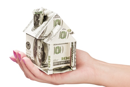 hand holds a house made from dollarsの写真素材