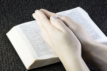 Prayer on the open Bible (focus on hands)の写真素材