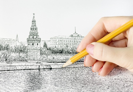 hand holds a pencil and draws the Moscow Kremlinの写真素材