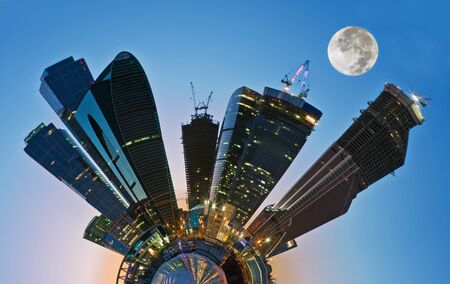 skyscrapers of the city at night against a full moon の写真素材
